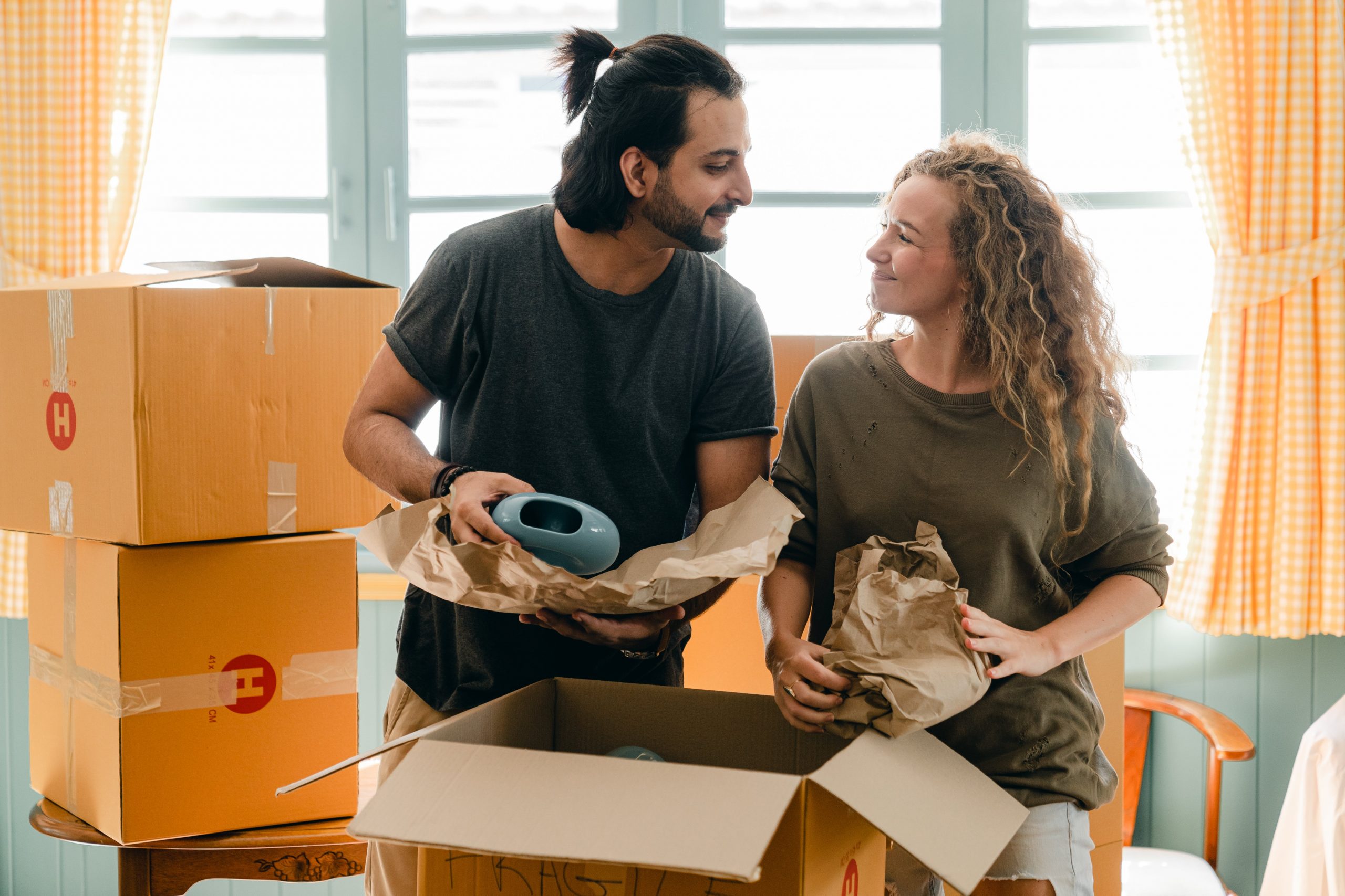 Man and woman packing fragile items for a move