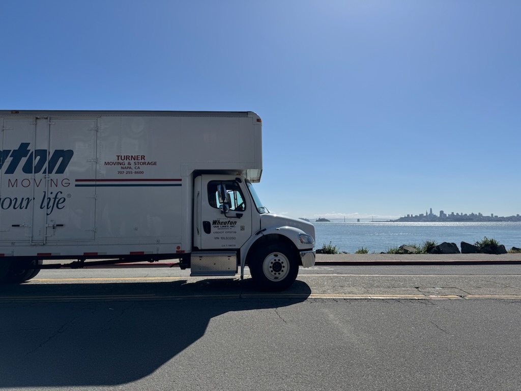 Turner moving truck on road with ocean in background