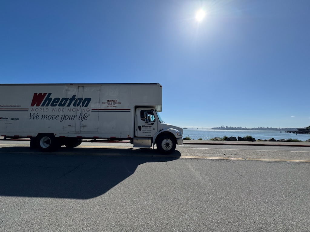 Turner moving truck on road with ocean in background